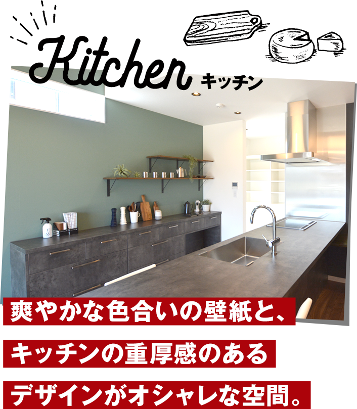 キッチンは、爽やかな色合いの壁紙と、キッチンの重厚感のあるデザインがオシャレな空間。